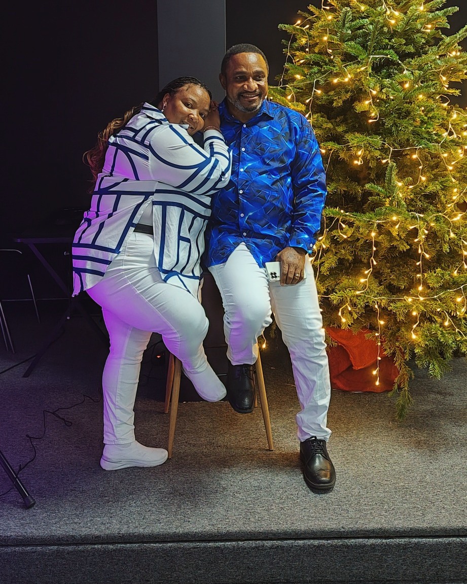 Mishael and Margaret Carson standing together beside a Christmas tree
